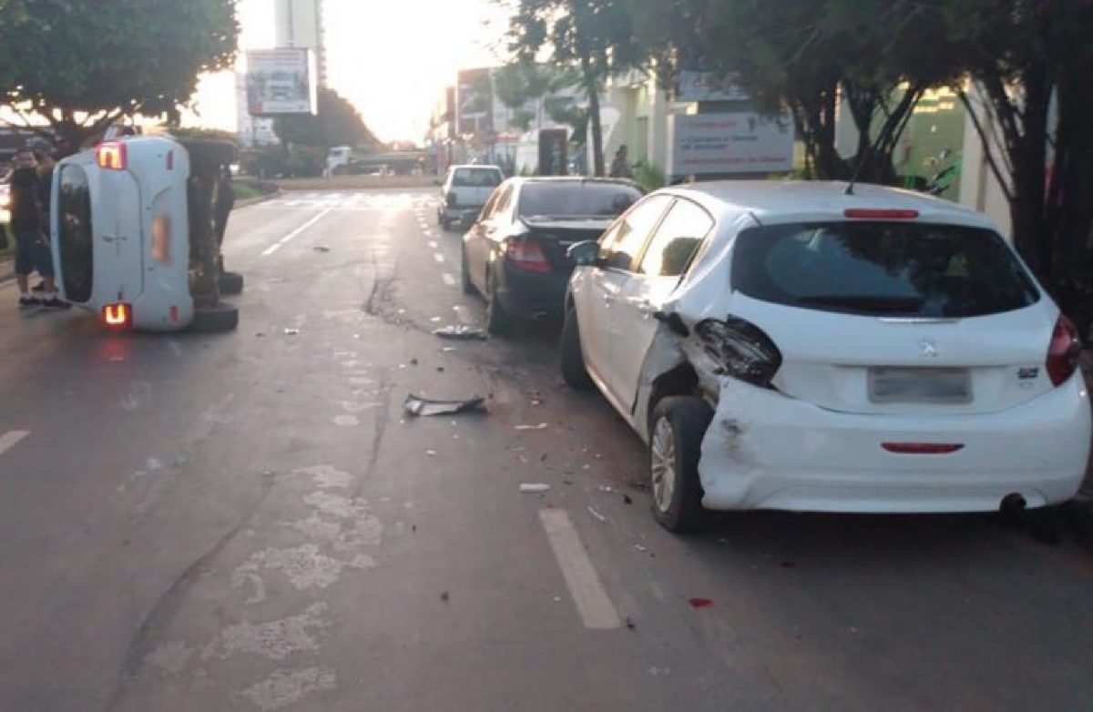 Motorista bêbado bate em carro estacionado e capota Sandero em avenida