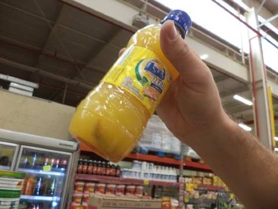 Fiscal mostra garrafa de suco em que larvas de inseto foram encontradas. (Foto: Geane Silva/Procon-AL)