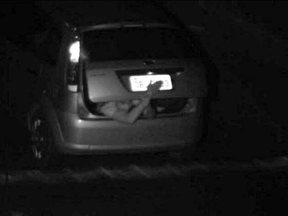 Um homem que estava no porta-malas de um veículo se arrisca ao colocar a mão para fora do carro para esconder a placa.
