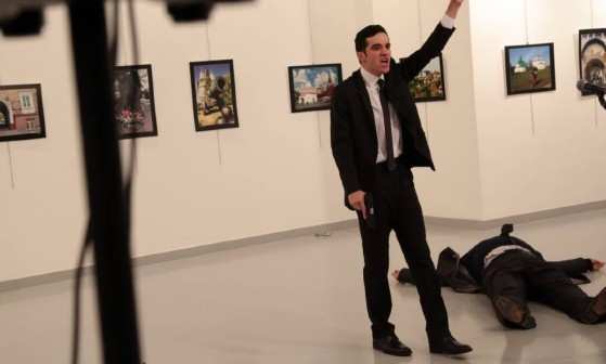 Homem armado gesticula perto de corpo de homem caído em galeria de arte de Ancara; embaixador teria sido ferido em ataque armado 