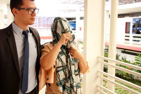 Shirlei Aparecida Matsouka Arrabal escondeu o rosto ao chegar para prestar depoimento no Fórum de Cuiabá.
