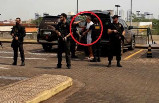 O ex-bicheiro João Arcanjo Ribeiro chega à sede da Justiça Federal escoltado por dez policiais federais.