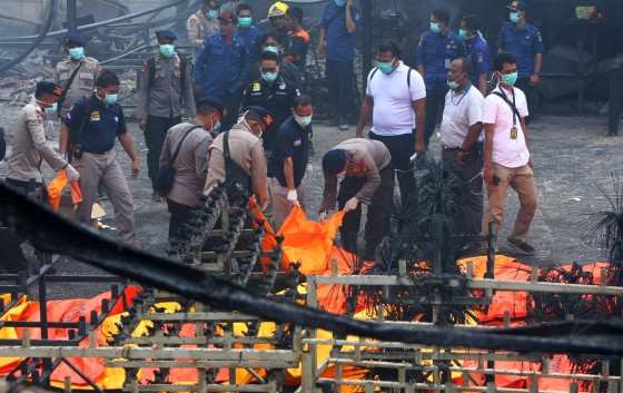 Policiais indonésios carregam corpos das vítimas de explosão de fábrica de fogos de artifício em Tangerang 