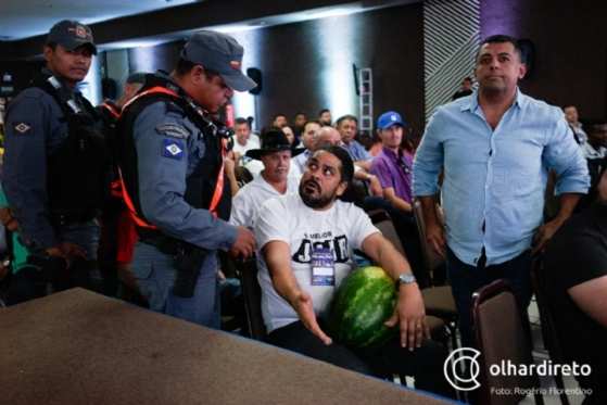 Homem protesto com melancia em ato.