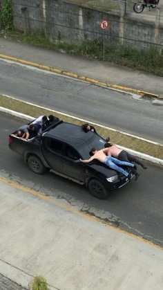 Reféns sobre o capô da caminhonete utilizada na fuga dos criminosos