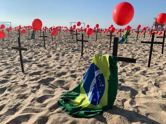 Cem cruzes são fixadas na areia com balões vermelhos. Há, ainda, soltura de 900 balões e um cartaz de quatro metros de comprimento.