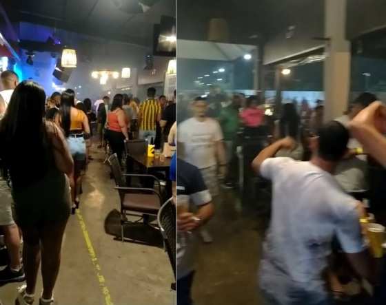 Bar funcionando como uma casa noturna em plena pandemia, com as pessoas em pé e dançando ao som de música alta