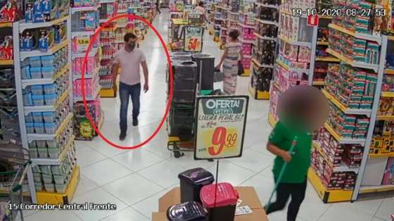 Outra câmera da loja mostra o homem andando de um lado para o outro.
