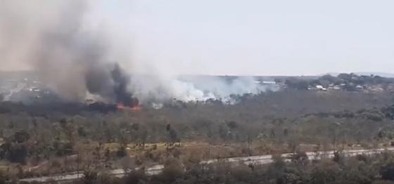 Em vídeos divulgados por sites locais, é possível ver o fogo alto na vegetação, uma área de fumaça e os bombeiros trabalhando para conter às chamas