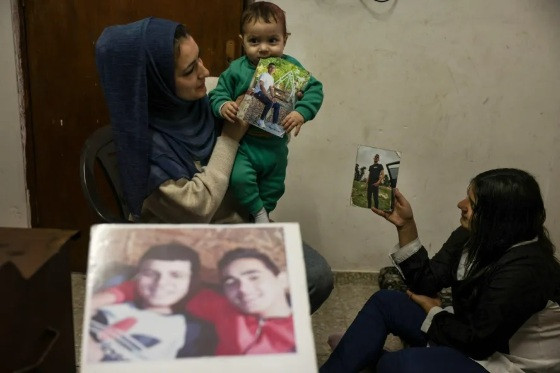 Familiares com fotos de prisioneiros palestinos incluídos na lista para serem libertados após acordo entre Israel e Hamas.