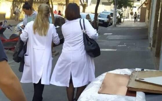Profissionais e estudantes desfilam com jalecos nas ruas.
