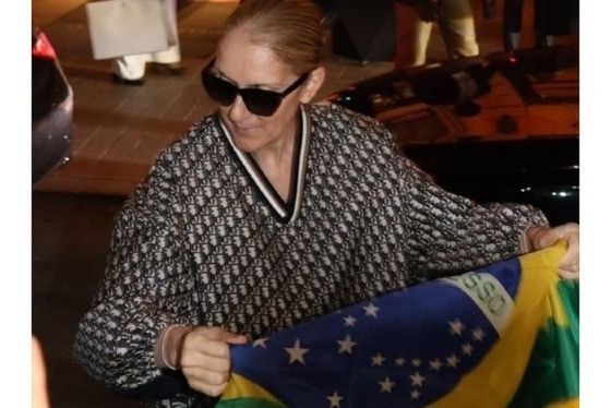 Céline Dion em Paris posando com a bandeira do Brasil