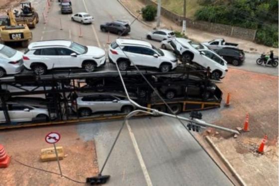 Carro transportado pelo caminhão-cegonha ficou preso nos cabos do semáforo.