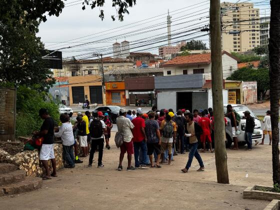 Moradores de rua recebendo marmitas no Morro da Luz.