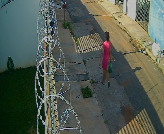 Larissa Karolina andando pela rua com gato morto dentro da sacola 