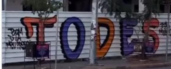 Tapume metálico em frente à Praça Alencastro aparece pichado com a palavra “todes”