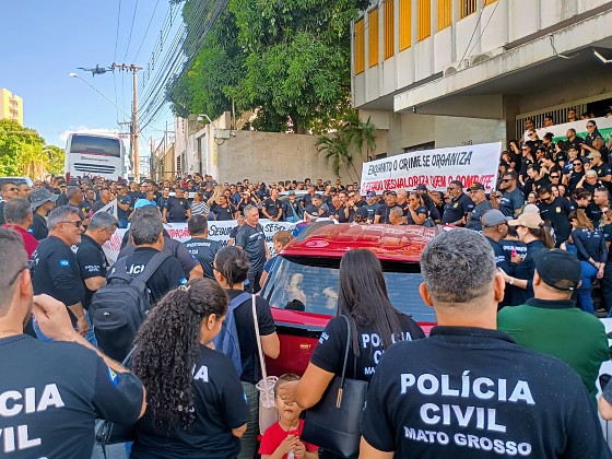 Escrivães e policiais com cartazes em frente à diretoria da Polícia Civil, em Cuiabá