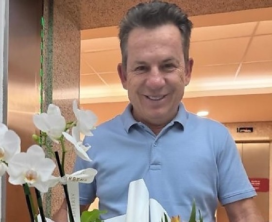 Virginia recebe buquê de flores de Mauro Mendes durante internação hospitalar.