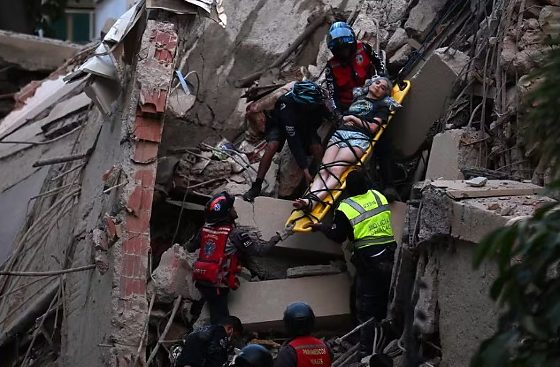 Equipes de resgate retiram mulher ferida de escombros de prédio que desabou em, Caracas, após terremoto
