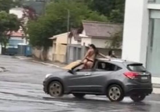 Vídeo mostra duas mulheres sem a parte de cima da roupa com o corpo para fora das janelas dianteiras de um Honda HR-V em movimento