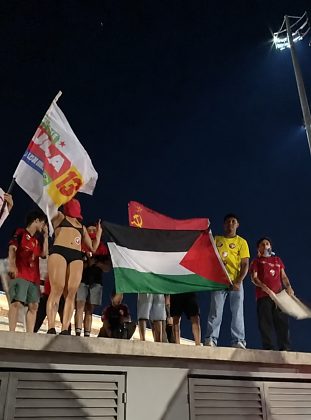 Participantes exibem bandeiras da Palestina e da antiga União Soviética durante manifestação em apoio a Lula na região da Arena Pantanal.