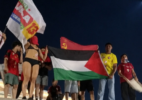 Participantes exibem bandeiras da Palestina e da antiga União Soviética durante manifestação em apoio a Lula na região da Arena Pantanal.